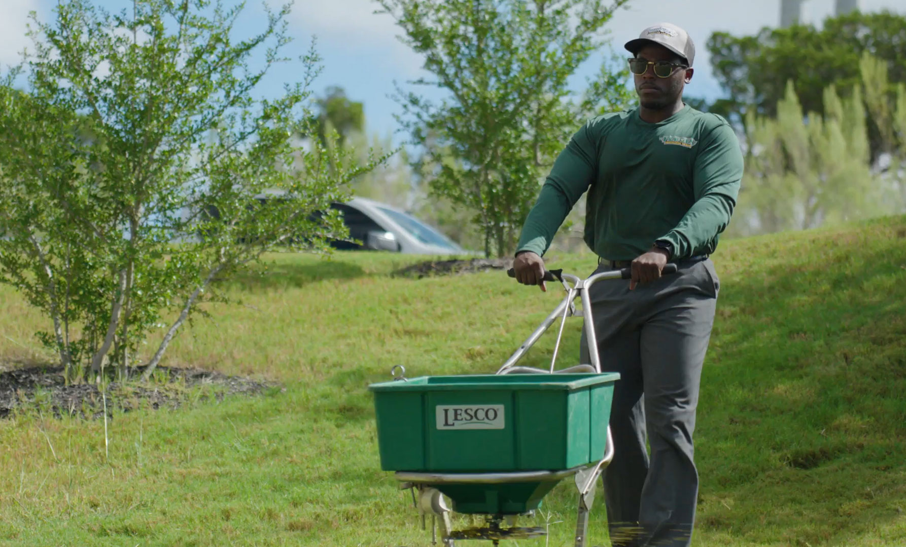 a lawncare professional deploying pre-emergent weed killer